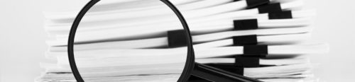 Stack of report paper documents with magnifying glass. Concept of business and search.